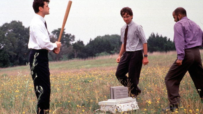 Screencap from the film Office Space of a printer getting divine justice from three office workers.